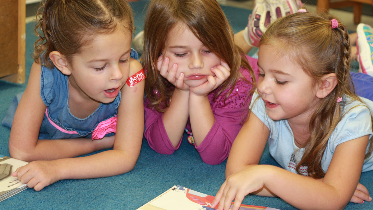 Preschool children reading a book